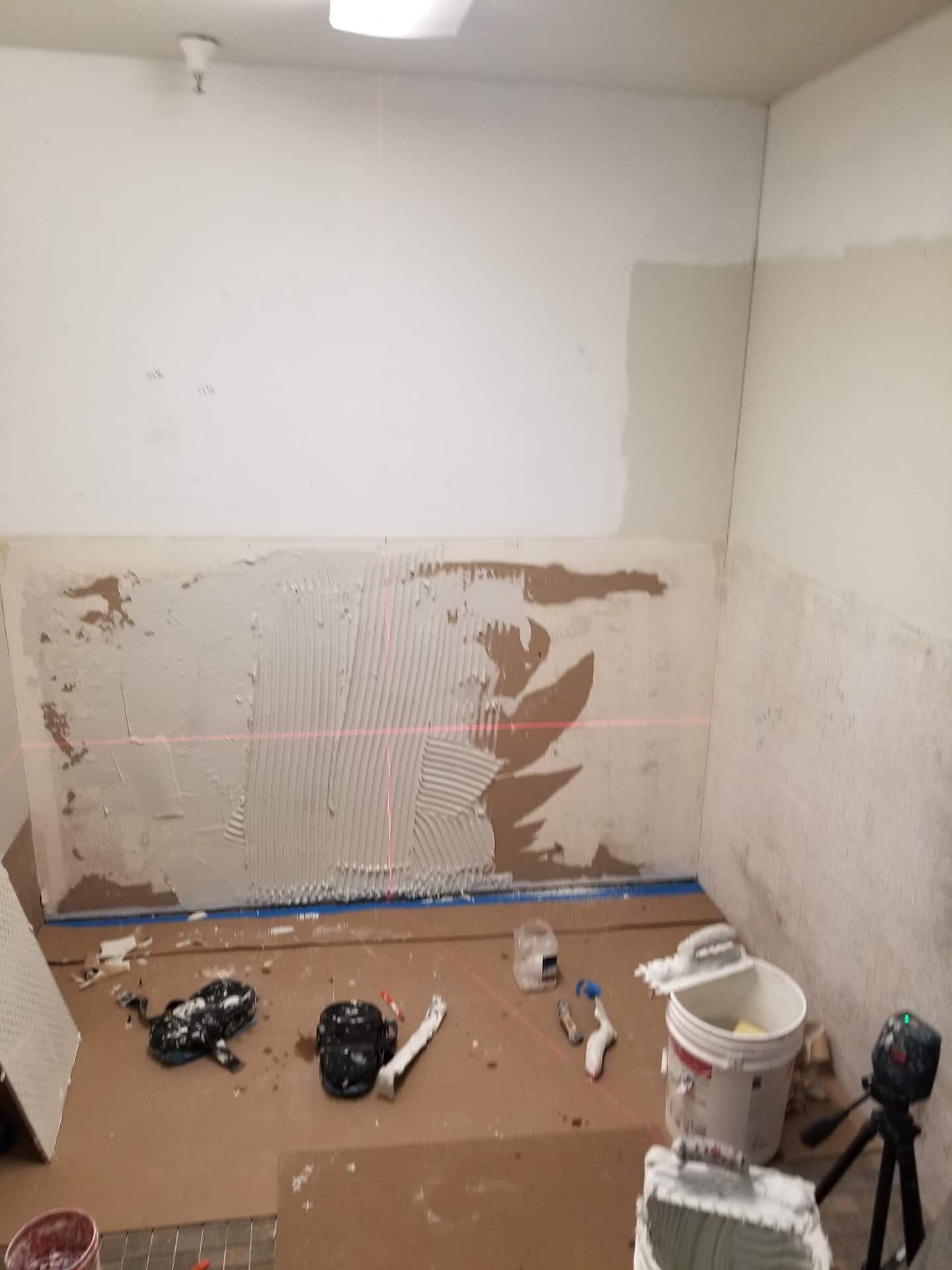 Before: Wall with thinset trowel lines applied, prep for tiling in bathroom