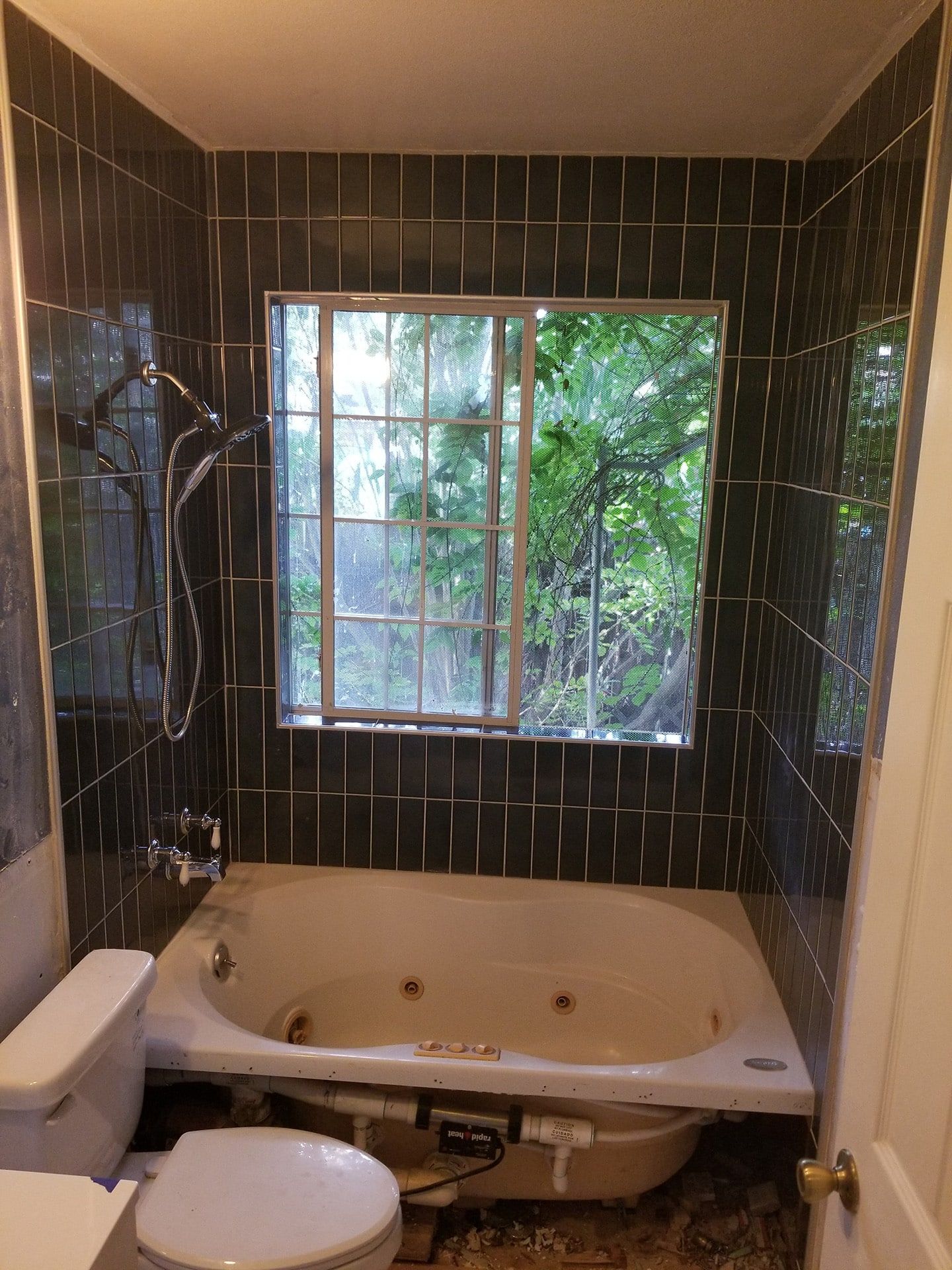 After: Dark green vertical tile tub surround with window and jetted tub