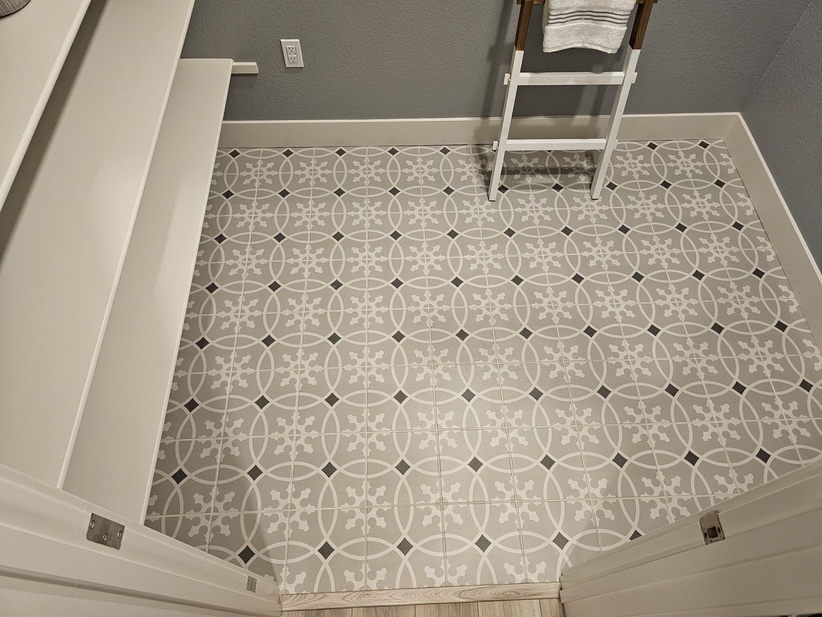 Gray and white patterned tile floor in small room corner