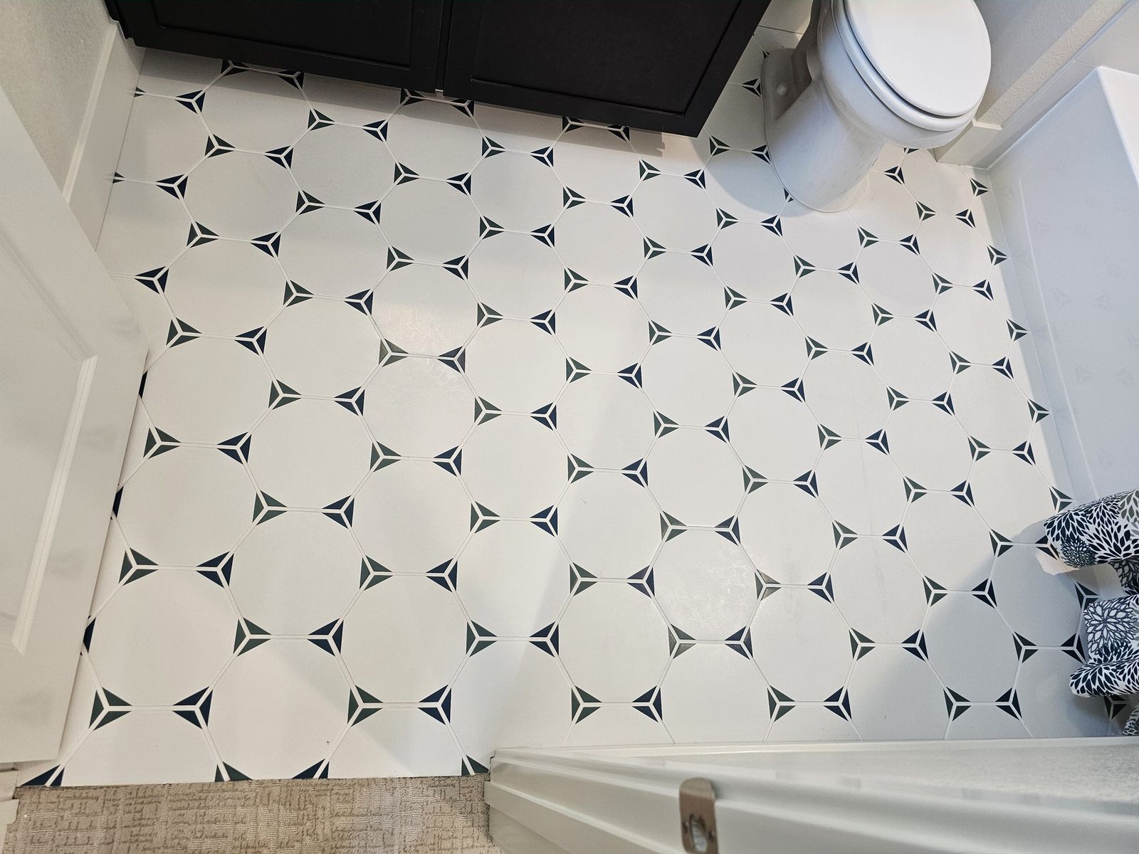 White hexagon floor tile with navy triangle pattern in bathroom