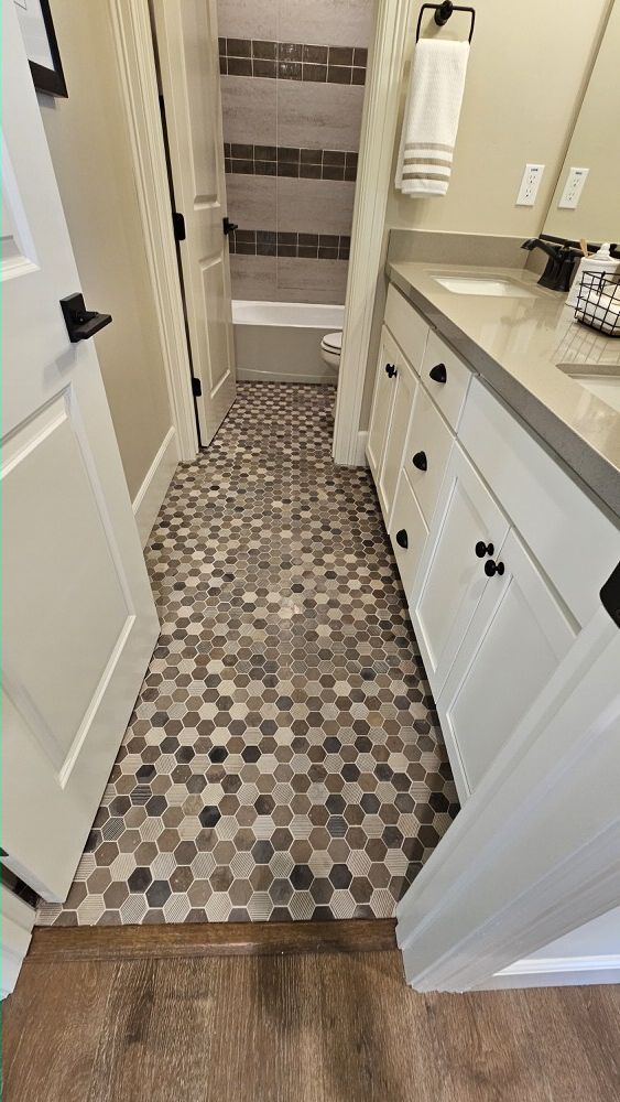 Hexagon mosaic tile floor in bathroom hallway with vanity