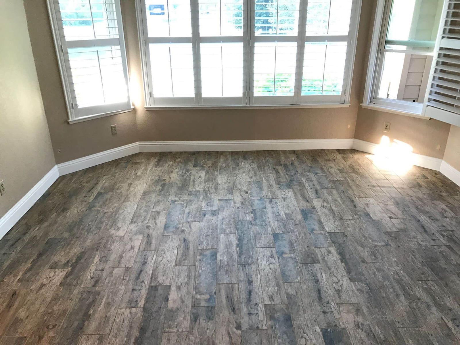 Wood-look plank tile floor in empty bay window room