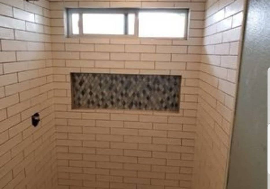 Subway tile shower with mosaic niche and small window