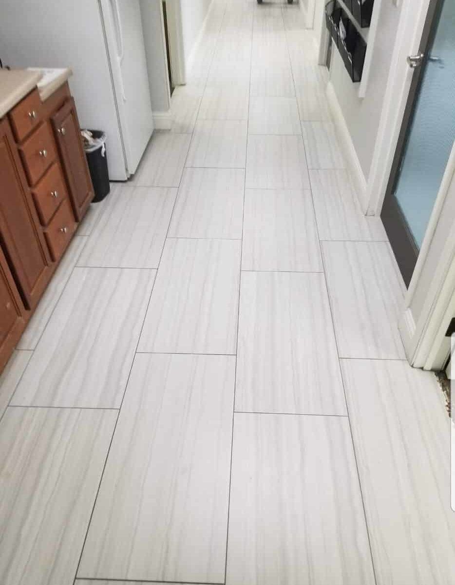 Long hallway with large plank-style light gray tile flooring